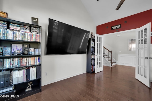 unfurnished living room featuring wood finished floors, vaulted ceiling, stairway, a ceiling fan, and french doors