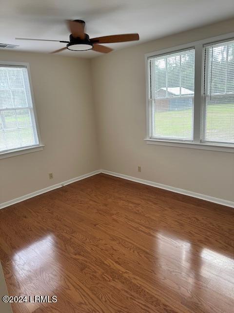 unfurnished room with hardwood / wood-style flooring, a wealth of natural light, and ceiling fan