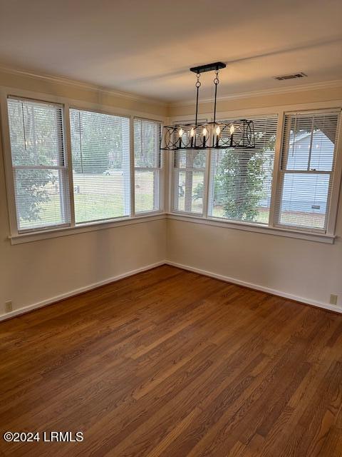 unfurnished dining area with a notable chandelier and dark wood-type flooring