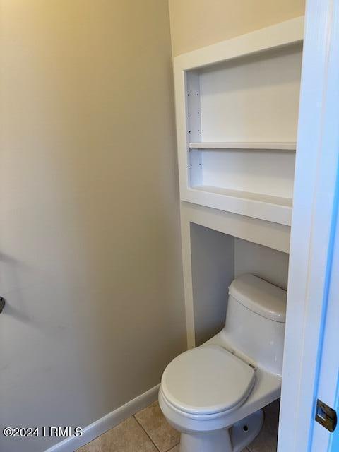 bathroom featuring toilet, tile patterned floors, and built in shelves