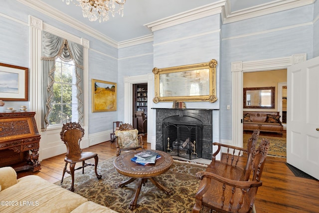 living area with a high ceiling, wood-type flooring, crown molding, and an inviting chandelier