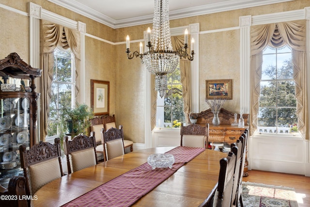 dining area with an inviting chandelier, hardwood / wood-style flooring, and ornamental molding