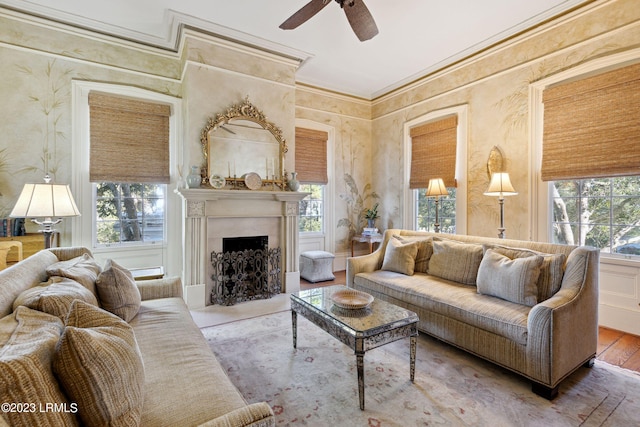 living room featuring a premium fireplace, ornamental molding, plenty of natural light, and wood-type flooring