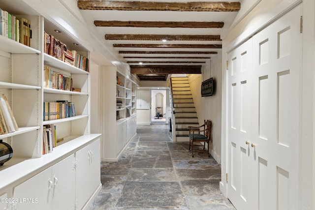 hallway featuring built in shelves and beam ceiling