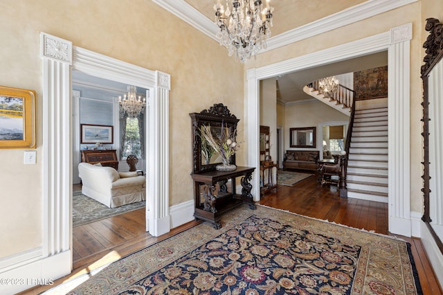 entrance foyer with crown molding, a notable chandelier, and dark hardwood / wood-style flooring