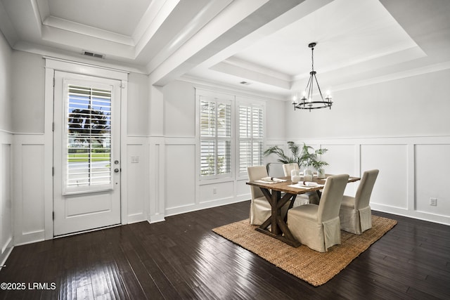 135 Danbridge Ct, Bluffton, SC 29910 - dining room featuring a raised ceiling, a decorative wall, a chandelier, dark wood-type flooring, and wainscoting