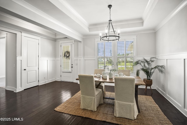135 Danbridge Ct, Bluffton, SC 29910 - dining space featuring a decorative wall, a tray ceiling, a chandelier, dark wood-style flooring, and crown molding