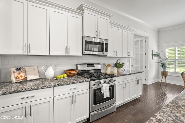 135 Danbridge Ct, Bluffton, SC 29910 - kitchen with appliances with stainless steel finishes, dark wood finished floors, backsplash, dark stone countertops, and crown molding