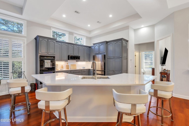 kitchen featuring a large island, appliances with stainless steel finishes, dark hardwood / wood-style floors, and a breakfast bar area