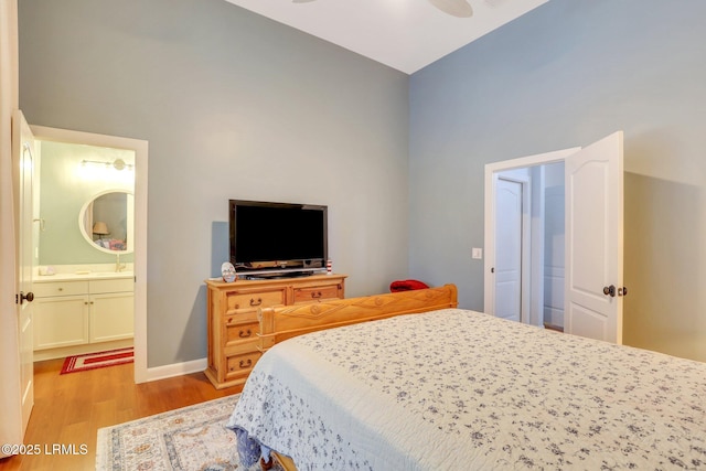 bedroom with ensuite bath, ceiling fan, and light wood-type flooring