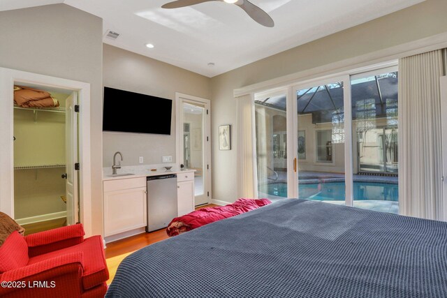 bedroom featuring sink, ceiling fan, a spacious closet, access to outside, and a closet