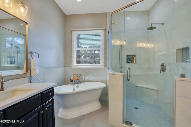 bathroom featuring shower with separate bathtub, tile walls, and vanity