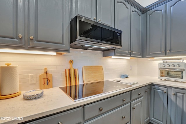 kitchen with tasteful backsplash, gray cabinetry, and black electric stovetop