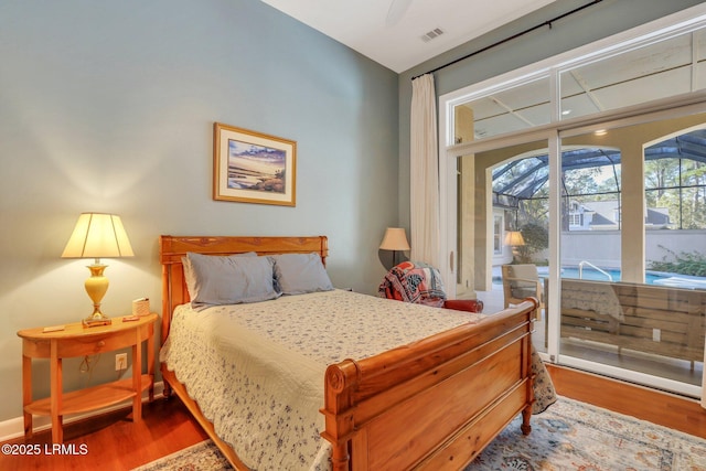 bedroom with ceiling fan, wood-type flooring, and access to exterior