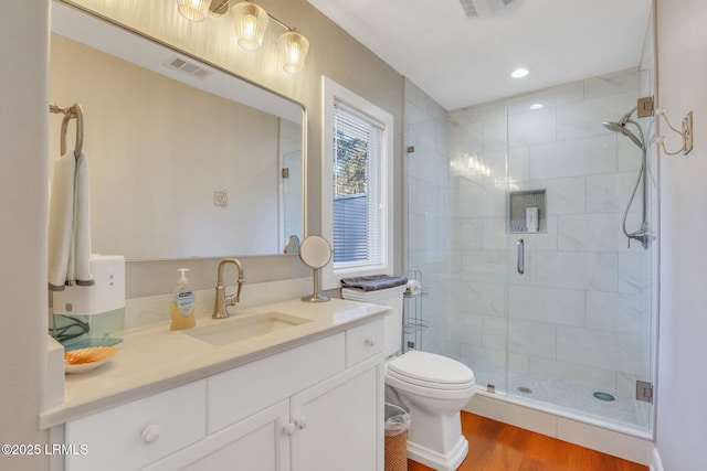 bathroom featuring vanity, toilet, an enclosed shower, and hardwood / wood-style floors