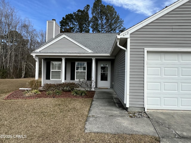 view of front of property with a garage, a front lawn, and a porch