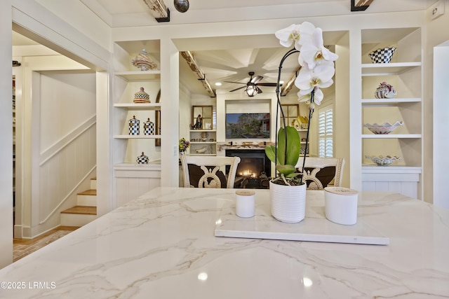 625 Spanish Wells Rd Unit 12, Hilton Head Island, SC 29926 - dining room featuring built in features, a ceiling fan, a warm lit fireplace, and stairs