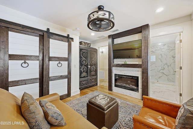 625 Spanish Wells Rd Unit 12, Hilton Head Island, SC 29926 - living room featuring visible vents, a barn door, wood finished floors, and a large fireplace
