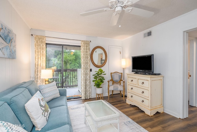 living room featuring dark hardwood / wood-style flooring, ceiling fan, and a textured ceiling