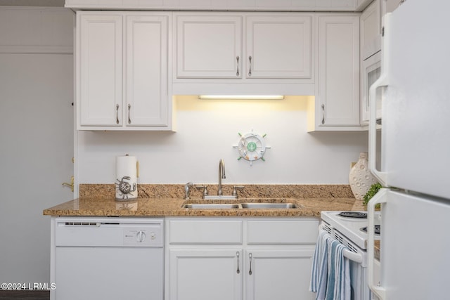 kitchen with white appliances, light stone countertops, sink, and white cabinets