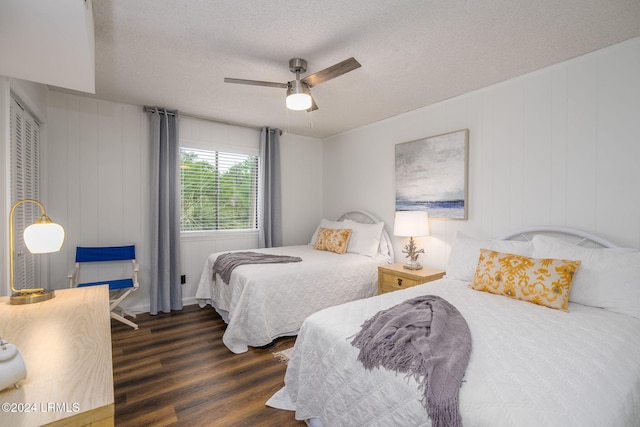 bedroom with dark wood-type flooring, ceiling fan, and a textured ceiling