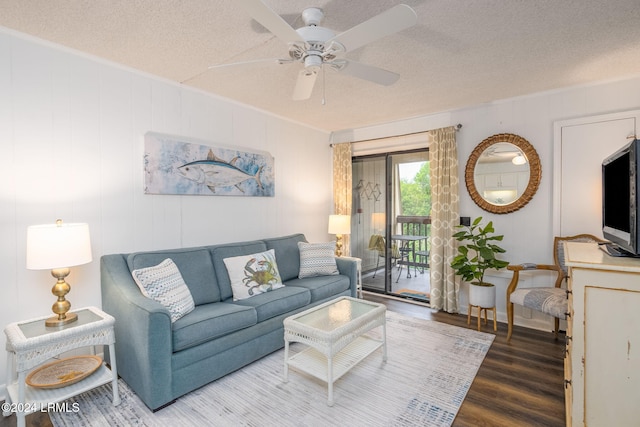 living room with ceiling fan, wood-type flooring, and a textured ceiling