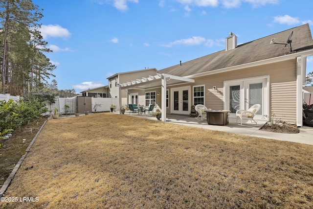 back of property featuring french doors, a pergola, a patio, and a lawn