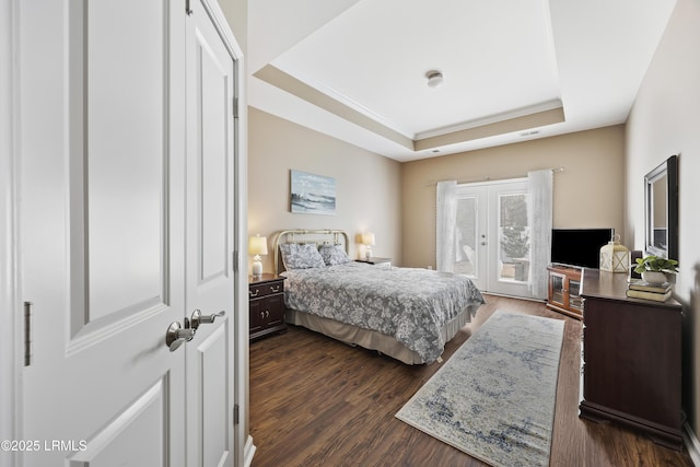 bedroom featuring french doors, crown molding, a tray ceiling, dark hardwood / wood-style flooring, and access to exterior