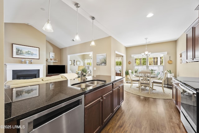 kitchen with decorative light fixtures, sink, dark brown cabinetry, stainless steel appliances, and dark wood-type flooring