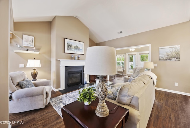 living room with french doors, dark hardwood / wood-style floors, and vaulted ceiling