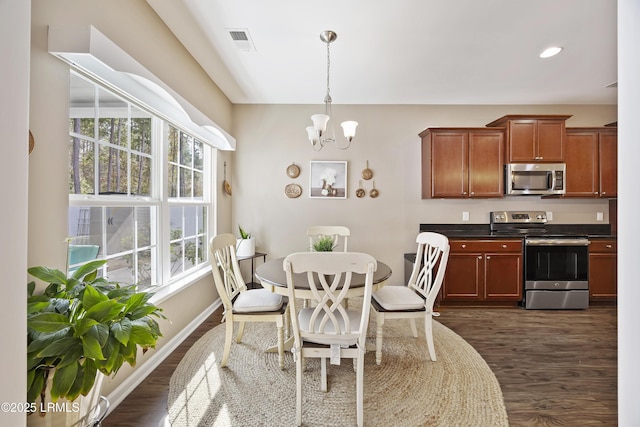 dining room featuring an inviting chandelier, dark hardwood / wood-style floors, and a healthy amount of sunlight