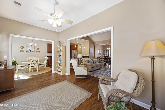 living room with lofted ceiling, ceiling fan with notable chandelier, and dark hardwood / wood-style floors