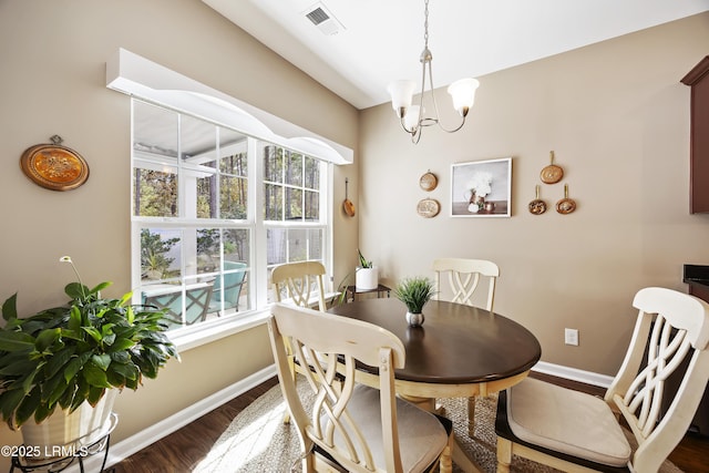 dining space featuring an inviting chandelier and dark wood-type flooring