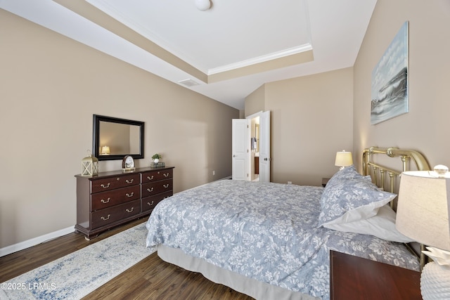 bedroom featuring crown molding, a tray ceiling, and dark hardwood / wood-style flooring