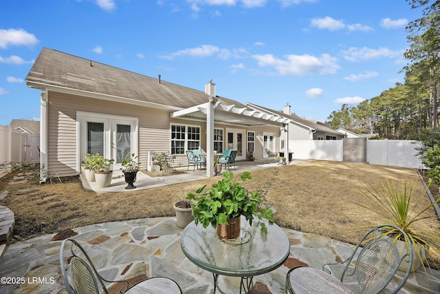 rear view of property featuring a pergola, a patio, and french doors