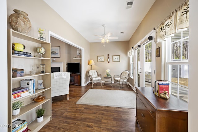 sitting room featuring dark wood-type flooring and ceiling fan