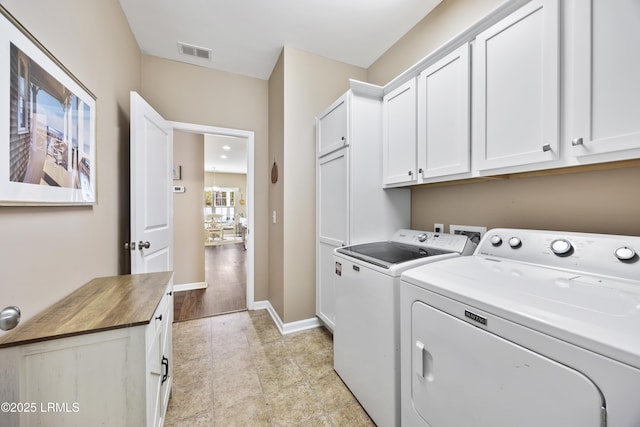 washroom with independent washer and dryer and cabinets