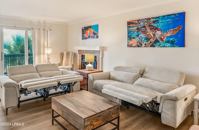 living room featuring a brick fireplace, ornamental molding, and hardwood / wood-style floors