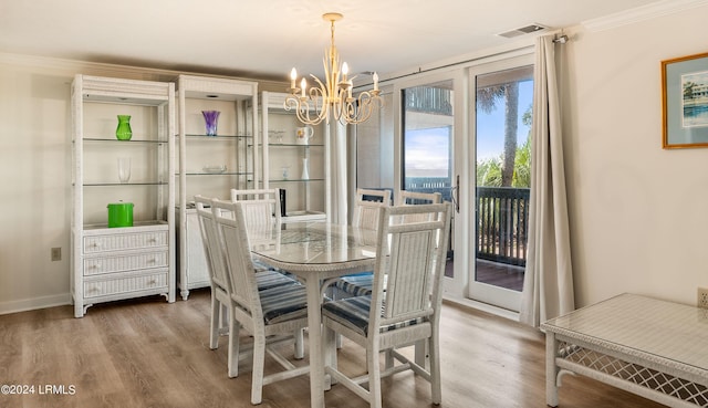 dining space featuring a notable chandelier, wood-type flooring, and ornamental molding