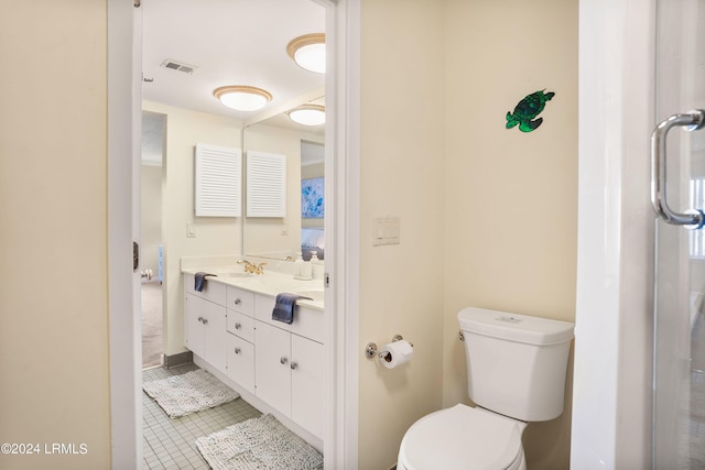 bathroom featuring vanity, toilet, and tile patterned flooring