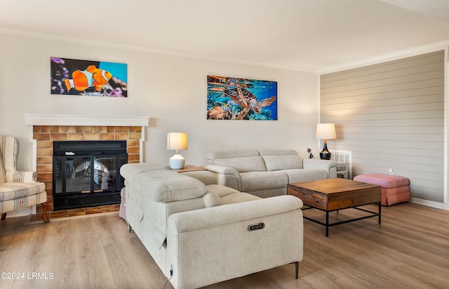 living room with hardwood / wood-style floors, crown molding, a fireplace, and wooden walls