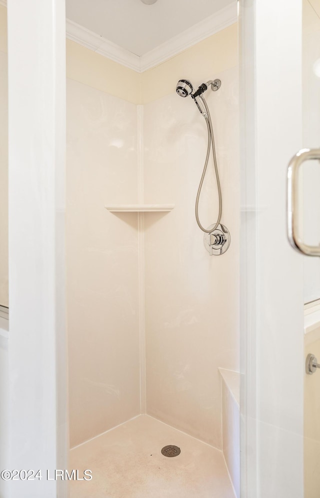 bathroom with ornamental molding and an enclosed shower