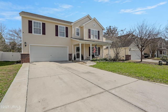 traditional home featuring covered porch, brick siding, fence, concrete driveway, and a front yard