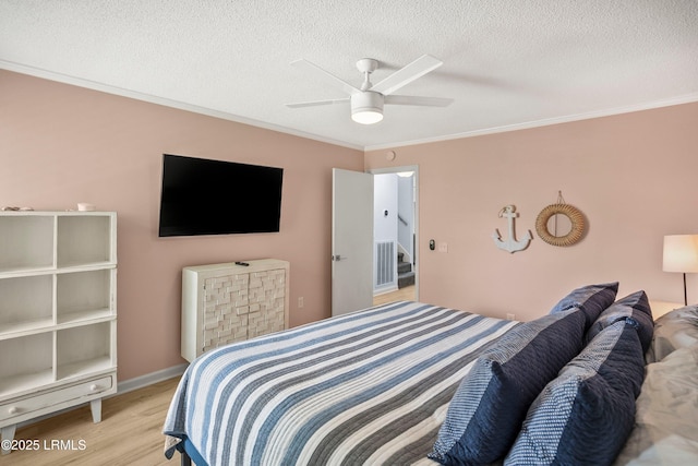 26 Fairway Club Dr, Fripp Island, SC 29920 - bedroom with a textured ceiling, ornamental molding, a ceiling fan, and light wood-style flooring