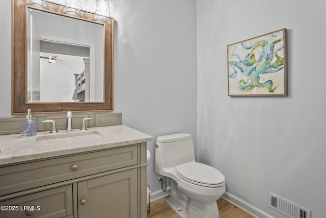 26 Fairway Club Dr, Fripp Island, SC 29920 - bathroom with visible vents, vanity, wood finished floors, toilet, and baseboards
