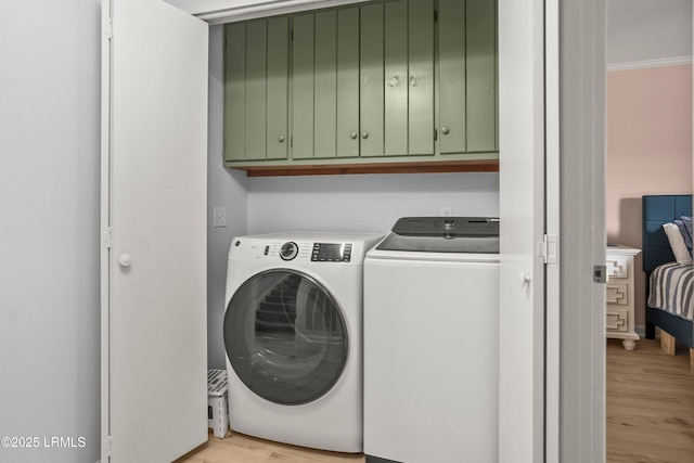 26 Fairway Club Dr, Fripp Island, SC 29920 - laundry area featuring crown molding, cabinet space, light wood finished floors, and washer and dryer