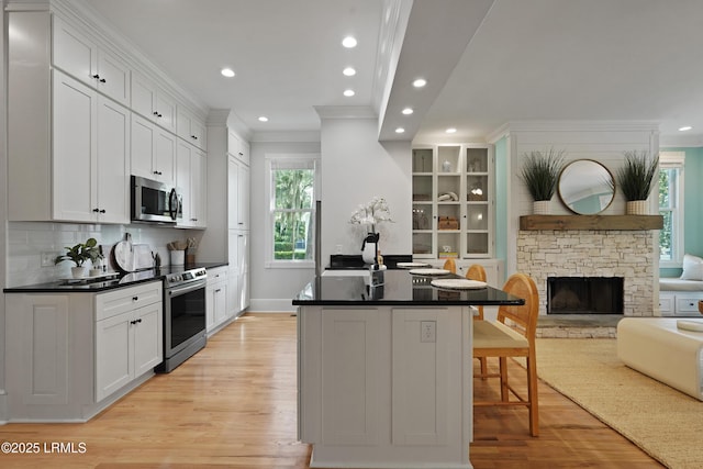 12 Sheffield Ct, Beaufort, SC 29907 - kitchen featuring stainless steel appliances, ornamental molding, light wood-style floors, open floor plan, and dark countertops