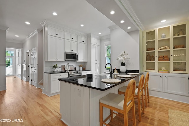 12 Sheffield Ct, Beaufort, SC 29907 - kitchen with stainless steel microwave, ornamental molding, a kitchen bar, light wood-type flooring, and healthy amount of natural light