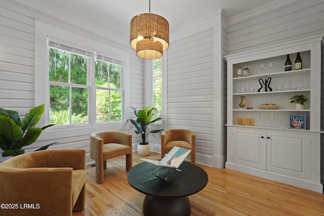 12 Sheffield Ct, Beaufort, SC 29907 - sitting room featuring a chandelier, light wood-style floors, crown molding, and wooden walls