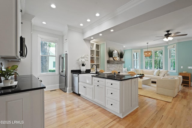 12 Sheffield Ct, Beaufort, SC 29907 - kitchen featuring appliances with stainless steel finishes, a sink, ornamental molding, dark countertops, and a peninsula